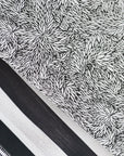 A selection of patterned wallpaper panels, featuring a black-and-white botanical print with a dense, abstract leaf design among other monochrome prints.