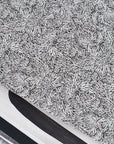 Close up of black and white botanical wallpaper with an intricate, abstract leaf pattern, layered among wallpaper prints