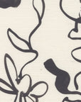 Close-up of grasscloth wallpaper featuring an black floral line drawing on a textured off-white background.