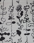 Grasscloth wallpaper with a repeating pattern of abstract black floral stirpe on an off-white textured surface.