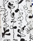 Close up of abstract floral patterned wallpapers in grayscale, black-and-white, and blue variations, featuring hand-drawn botanical elements on a white background.
