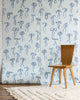 Silk wallpaper with hand-drawn blue bows on a soft blue background, styled with a wooden chair and a textured cream rug.