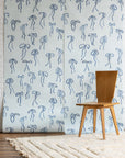 Silk wallpaper with hand-drawn blue bows on a soft blue background, styled with a wooden chair and a textured cream rug.