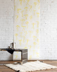 Cheerful wallpaper with hand-drawn yellow bows on a white background, styled with a modern metallic coffee table and a cozy cream rug.