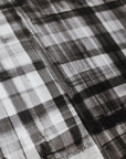 Close-up of black and white plaid wallpaper with a hand-painted, watercolor-like texture, featuring soft brushstrokes and layered transparency.