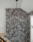 Stairwell with grasscloth wallpaper featuring an abstract black and white geometric pattern, contrasted against white walls and large windows.
