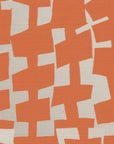 A close-up of geometric-patterned grasscloth wallpaper in bold orange and off-white, showcasing an abstract arrangement of irregularly shaped blocks.