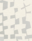A close-up of geometric-patterned grasscloth wallpaper in soft gray and off-white, displaying an abstract arrangement of irregularly shaped blocks in a subtle, neutral palette.