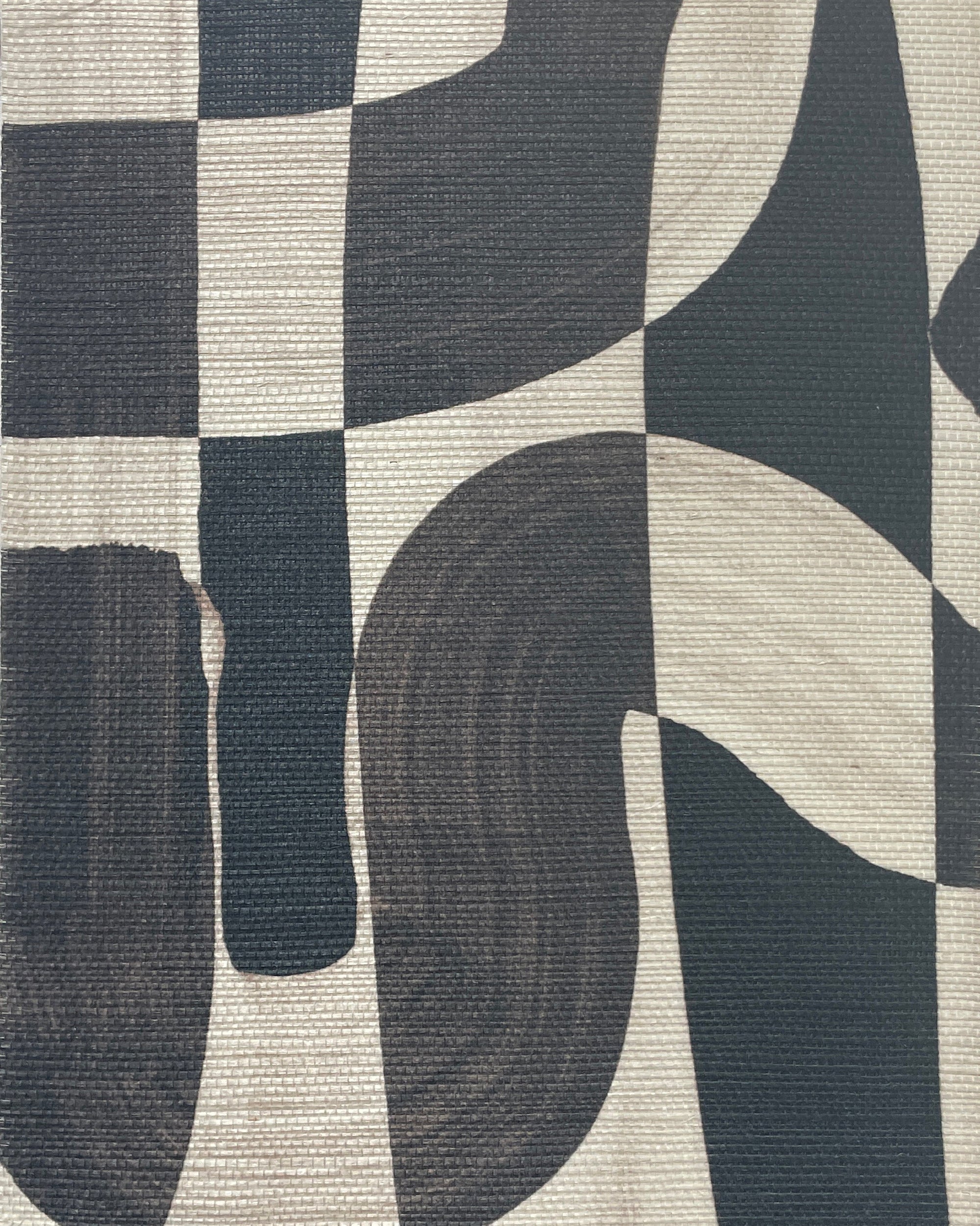 Extreme close-up of black-and-white grasscloth wallpaper, highlighting the bold, abstract brushstroke pattern and textured woven material.