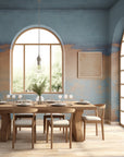 Blue and sandy beige gradient wallpaper with a painted sky effect, wrapping around a modern dining room with arched windows and wood furniture.