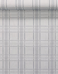 Light grey plaid linen wallpaper with charcoal and white lines, partially unrolled to display the texture and structured grid design.