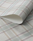 Rolled linen wallpaper featuring a soft pastel plaid pattern in muted sage green, taupe, and mauve on a cream-toned woven-texture background.