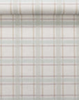 Partially unrolled linen wallpaper showcasing a delicate plaid design in sage, beige, and mauve tones on a soft linen surface