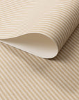 Close-up of real linen wallpaper roll with warm tan and cream vertical stripes.