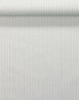 Rolled wallpaper showing delicate sage green and ivory stripes with a woven fabric-inspired finish of real linen.