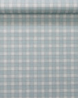 Rolled section of vintage plaid check wallpaper in soft blue and white, showing the texture and alignment of the pattern.
