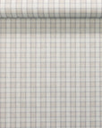 Rolled section of wallpaper showing vintage plaid check pattern in beige and grey-blue on a natural linen.