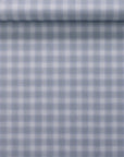 Rolled wallpaper sample showcasing vintage plaid check pattern in soft periwinkle and white on a natural linen.