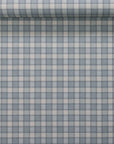 Rolled sample of vintage plaid check wallpaper in blue and ivory tones with visible linen texture and aligned pattern.