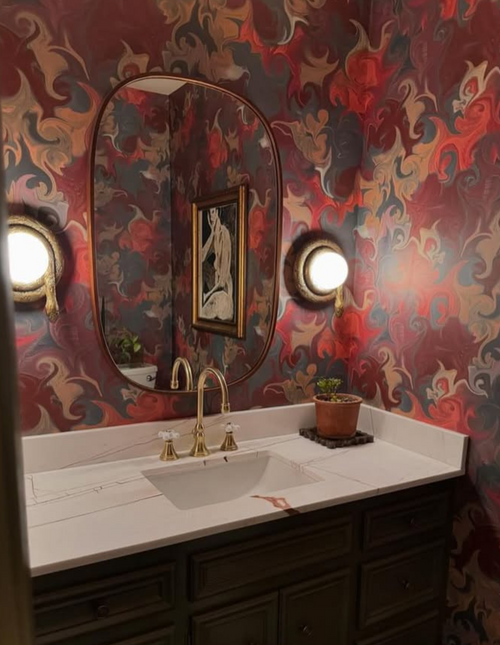 Vintage-inspired powder room with dramatic marbled wallpaper and gold fixtures
