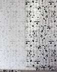Display of painted floral wallpapers in grayscale and black-and-white variations, hung side by side to showcase different artistic interpretations of botanical stripe elements
