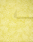 Vibrant yellow green wallpaper with an abstract swirling pattern of wavy cream colored lines radiating from circular centers, partially unrolled.