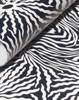 Rolled-up black and white wallpaper with bold wavy patterns, showcasing its
striking, contemporary aesthetic.