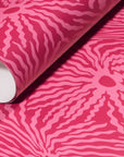 Rolled-up pink wallpaper with striking magenta wave-like patterns, emphasizing its bold and dynamic style.