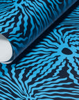 Rolled-up navy wallpaper with striking electric blue wave-like patterns,
highlighting its bold contrast and fluid movement.