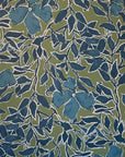 Vibrant silk wallpaper with a rich green background, deep blue leaves, and flowers outlined in white, creating a bold, hand-painted botanical pattern.