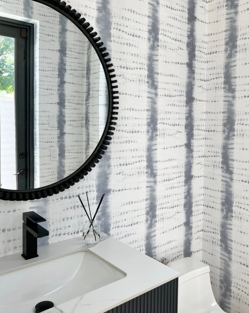 Shibori stripe wallpaper in blue and white adds texture to a contemporary bathroom