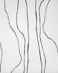 Close-up of white wallpaper featuring irregular black vertical lines, adding a modern, artistic touch.