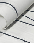 Rolled-up white wallpaper with striking black wavy stripes, showcasing its contemporary and minimalist design