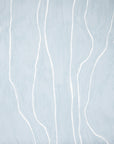 Close-up of light blue wallpaper featuring flowing white vertical lines, creating a serene and modern aesthetic.