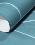 Rolled-up teal wallpaper with elegant white wavy stripes, showcasing its subtle texture and sophisticated style.