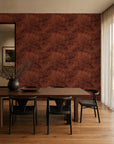Rust red hand-sketched foliage wallpaper installed in a dining room