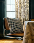 Black and ivory checkerboard throw pillow styled on white boucle sofa