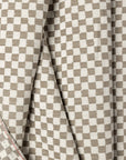 Light gray and cream checkerboard jacquard upholstery fabric by the yard, folded showing drape and weight