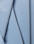 Light blue velveteen upholstery fabric by the yard, folded showing drape and weight