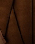 Dark brown velveteen upholstery fabric by the yard, folded showing drape and weight
