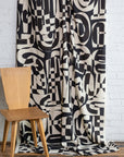 Black and cream abstract printed linen fabric by the yard, draped to show pattern and scale