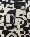 Black and cream abstract printed linen fabric by the yard, folded showing drape and weight
