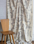 Gray and cream abstract printed linen fabric by the yard, draped to show pattern and scale