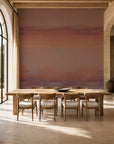 Rose and plum sunset ombre mural wallpaper installed in a sunlit dining room