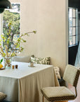 Olive green checkerboard jacquard fabric upholstered with matching pillows in a breakfast nook with blossom branches