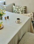 Brown striped linen wallpaper hung on the wall on a nook table set with an espresso cup