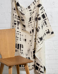 Cream and black brushstroke crosshatch linen fabric by the yard, draped to show pattern and scale