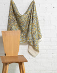 Olive gold and blue botanical leaf printed linen fabric by the yard, draped to show pattern and scale