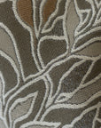 Close-up of woven botanical leaf pattern on sage green jacquard throw pillow