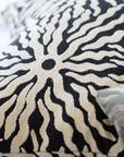 Close-up of woven sunburst pattern on black and ivory jacquard throw pillow